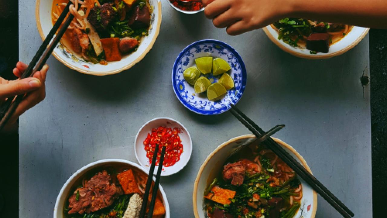 Hands reaching for food on table
