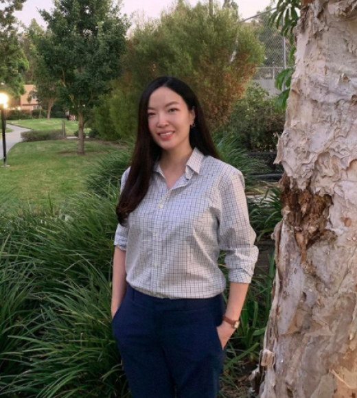 Professor Chung stands beside a tree