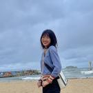 Photo of Se Youn smiling at camera by a beach